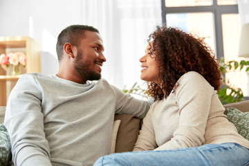 relationships and people concept - happy african american couple at home