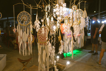 Dreamcatcher, boho chic feathers, ethnic amulet, symbol. With beads of rope hanging. Talisman for a dream. Witchcraft and secrets. Witchcraft and fortune telling