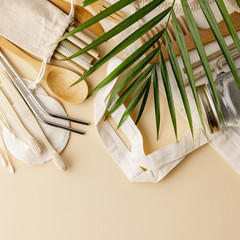 Cotton bag, bamboo cultery, glass jar, bamboo toothbrushes, hairbrush and straws on color background, flat lay.