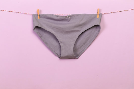 Female panties hanging on rope on pastel background - Image  - Image