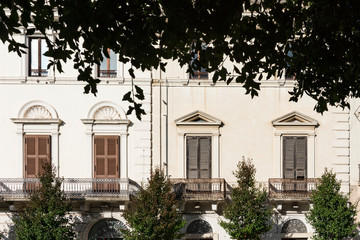 Fototapeta na wymiar white apartments white balcony and brown shutters. Altamura, Italy