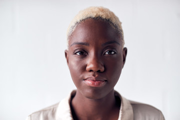 Portrait Of Determined Young Businesswoman Standing Against White Studio Wall
