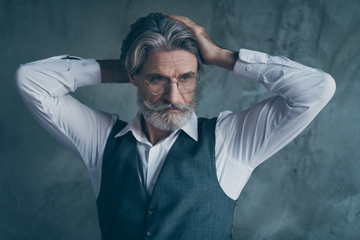 Portrait of charismatic modern virile old man look copy space touch hairstyle after spa salon therapy wear grey vest white shirt isolated over concrete wall background