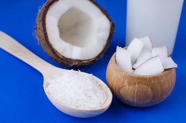 Natural coconut milk, coconut shavings, coconut chips on a blue background. The concept of healthy food.