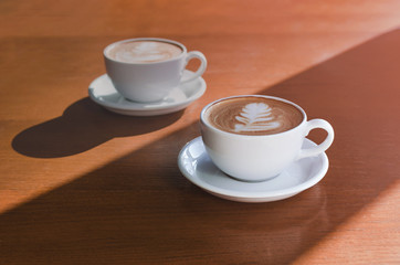 Obraz premium Two morning cups of coffee on wooden background