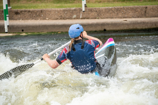 C1W Class GB Canoe Slalom Athlete In White Water Action Paddling Away From Camera