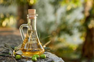 Olive oil and olive berries with leaves outdoor