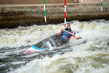 GB Canoe Slalom Athlete in the women's C1W class stretching to get around the pole of a slalom gate...