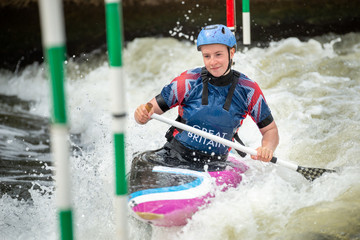 Close up of a happy GB Canoe Slalom Athlete negotiating the poles of slalom gates on white water in...