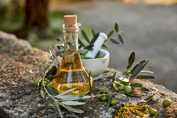 Olive oil and olive berries with leaves outdoor