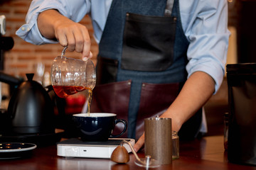Hand of barista pouring coffee at coffee shop, Barista making coffee.