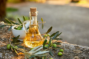 Olive oil and olive berries with leaves outdoor