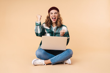Photo of pretty excited woman making winner gesture using laptop - obrazy, fototapety, plakaty