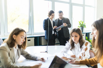 Team of young business professionals using technology in an informal meeting engaged on architect design. . Concept of successful startup