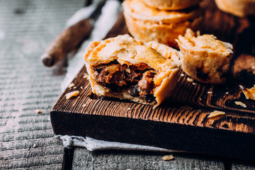 Fresh Traditional Australian meat mini pie on the wooden board on table background, closeup with copy space, rustic style - 324197522