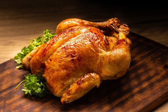 Roasted whole chicken on wooden cutting board