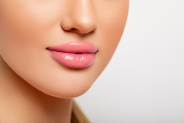 Beautiful Lips Close-up. Makeup. Lip shiny Lipstick. Sexy Lips. Part of Face, Young Woman close up. Perfect plump Lips bodily Lipstick. Peach Color of Lipstick on Large Lips. Perfect Makeup. 