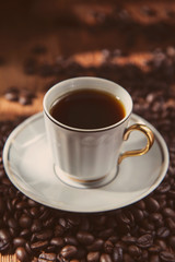 coffee beans and cup on a wooden background close up toning photo