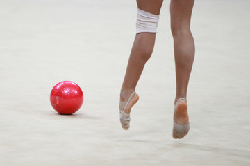 Young woman gymnast legs with a ball