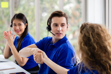 Team call center worker and operators with microphone and computer at work shaking hand, Call center, support telemarketing.