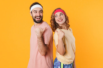 Portrait of athletic couple smiling and pointing fingers at each other