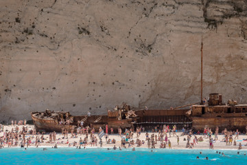 Navagio, shipwreck beach with white sand, full of tourists bathers in Zante, Zakynthos, Greece