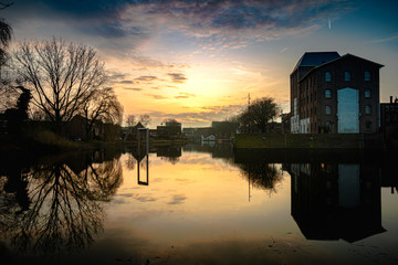 Fototapeta premium An old industrial building on a pond during the sunset in Deventer, the Netherlands