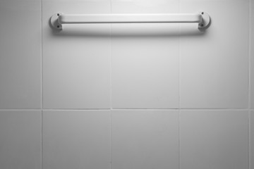 Clothes rack on the white tile wall in  the bathroom