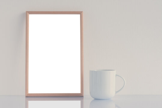 White coffee cup and blank picture frame mock up