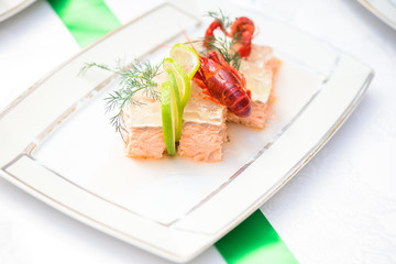 Fish dish with slice of lime, jelly and crayfish on the plate