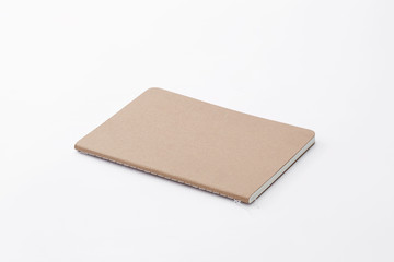 Top view of closed stitch blank recycled paper cover notebook on white background.