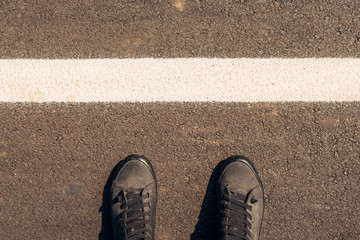 Urban explorer, man in modern shoes standing on asphalt road