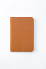 Top view of closed stitch blank recycled paper cover notebook on white background.