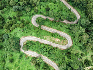 Aerial view of winding asphalt road for background.Scenic view of Sharp curve road on the mountain by drone safty drive and travel concept.