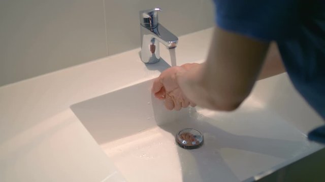 Man washing hands under flowing water from faulty tap in 4K slow motion 60fps - Powered by Adobe
