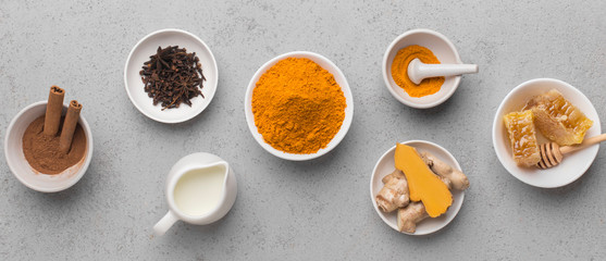 Obraz na płótnie Canvas Organic turmeric spices with ginger and honey on gray