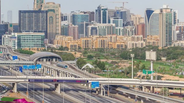Dubai Golf Course with a cityscape of Gereens and tecom districts at the background aerial timelapse. Traffic on sheikh zayed road with junction and metro starion