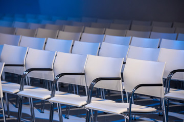 Fototapeta premium White chairs in a conference hall perfectly aligned