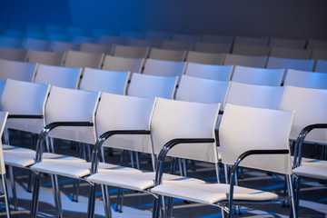 White chairs  in a conference hall perfectly aligned