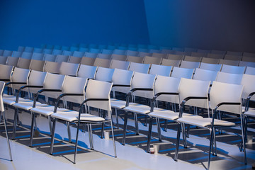 White chairs  in a conference hall perfectly aligned