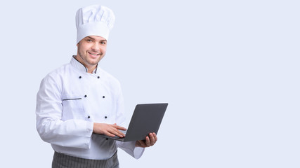 Cheerful Chef With Laptop Browsing Internet Standing In Studio, Panorama