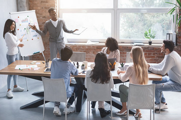 Black guy and asian girl making presentation at office