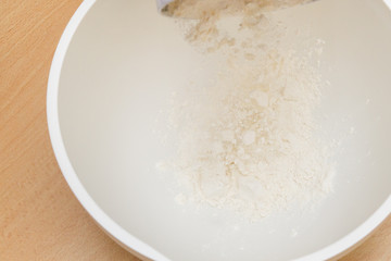 Cooking dough in a white plastic bowl at home