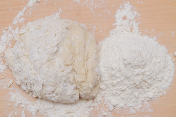 Prepared kneaded dough on a wooden table at home