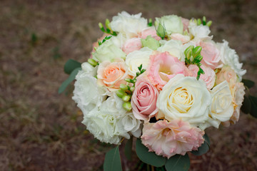 Side view of a beautiful delicate wedding bouquet of cream roses and eustoma blurred background