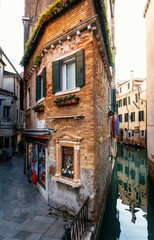 Obraz premium View of the thin colorful house between canal and street in Venice, Italy