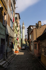 Narrow street in Istanbul's historic district. View of the minaret of the ancient  Akbiyik Mosque . Turkey