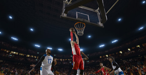 Basketball players on big professional arena during the game. Tense moment of the game. View from below the basket