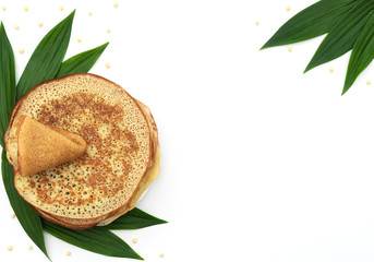 Fototapeta na wymiar Homemade pancakes on white background with green leaves and beads. Maslenitsa, spring festival concept. Russian traditional food. Pancake week. Delicious breakfast. Flat lay style with copy space.