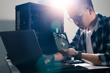 The technician hold the screwdriver for repairing the computer. the concept of computer hardware,...